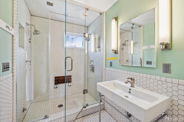 bathroom featuring a sink, tile walls, and a shower stall