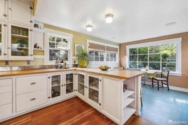 kitchen featuring open shelves, glass insert cabinets, butcher block countertops, and white cabinetry