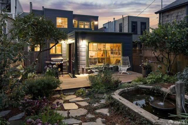 rear view of house with a wooden deck and fence