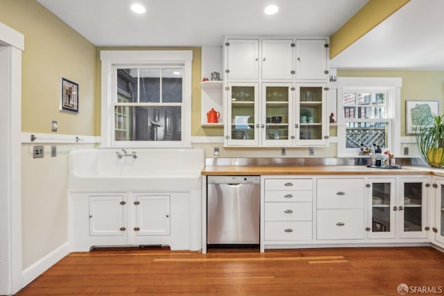 kitchen with wood finished floors, white cabinetry, and stainless steel dishwasher