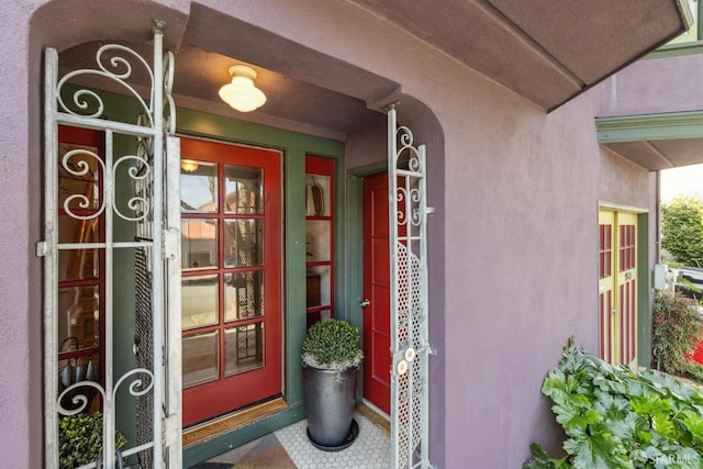 view of exterior entry with stucco siding