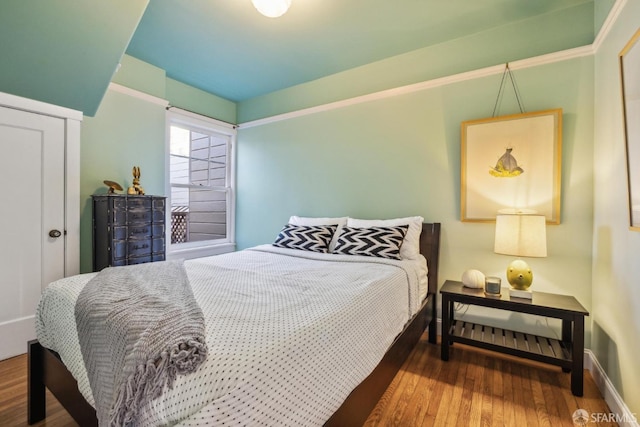 bedroom with baseboards and wood finished floors