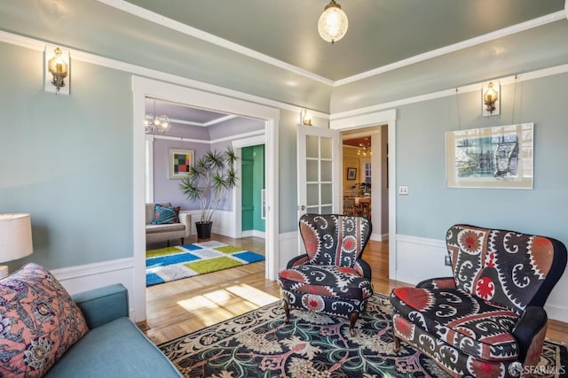 living area with crown molding and wood finished floors