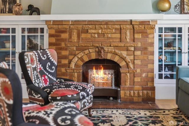 room details featuring french doors and a warm lit fireplace