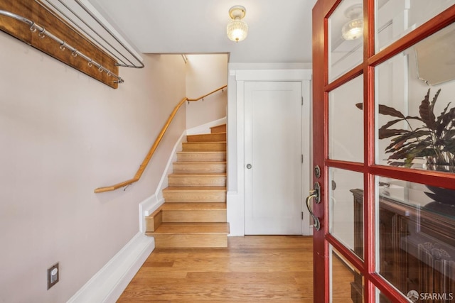 stairs featuring wood finished floors and baseboards