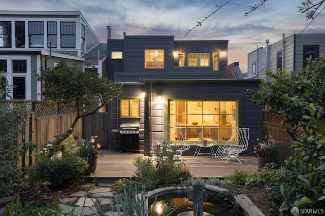 rear view of house featuring a wooden deck and fence