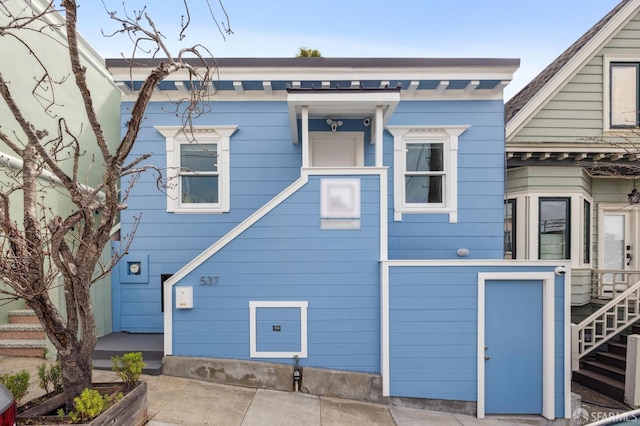 back of house featuring stairway