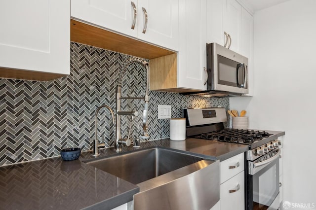 kitchen featuring appliances with stainless steel finishes, decorative backsplash, and white cabinets