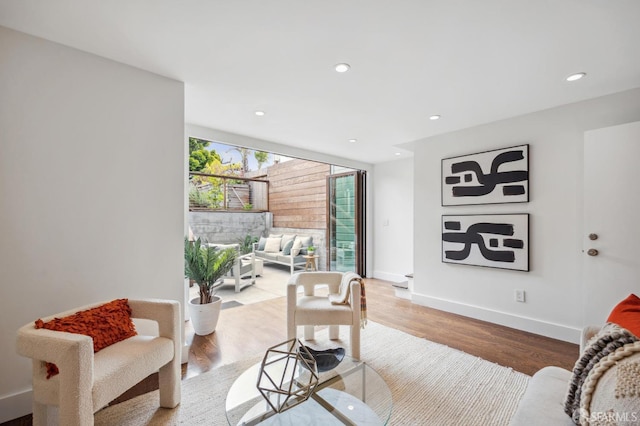 living room featuring light wood-type flooring, recessed lighting, and baseboards