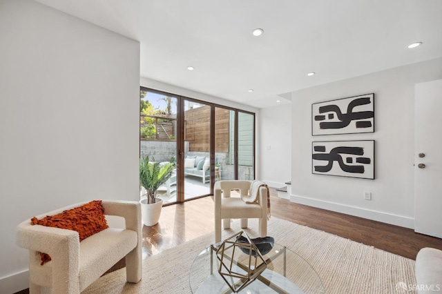 living area featuring wood finished floors, recessed lighting, and baseboards