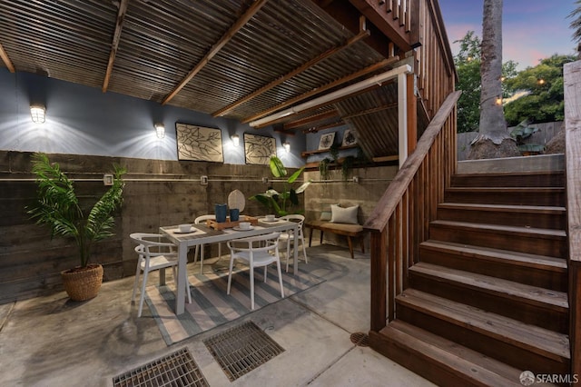 view of patio / terrace featuring outdoor dining space, fence, and stairs