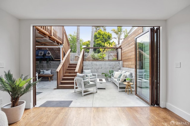doorway to outside featuring stairway, wood finished floors, and baseboards
