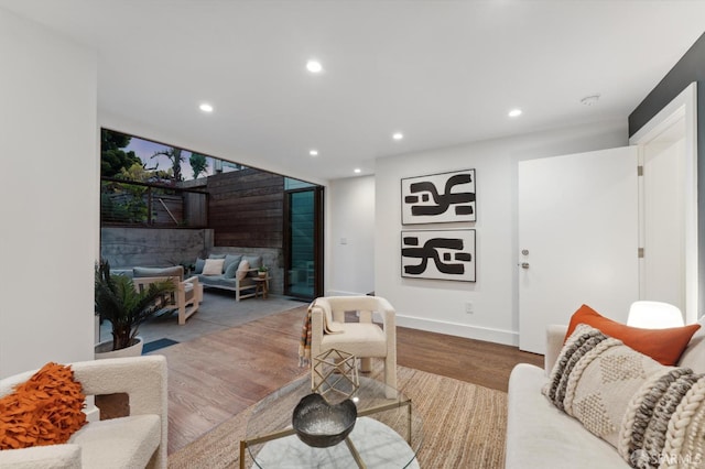 living area featuring recessed lighting, wood finished floors, and baseboards