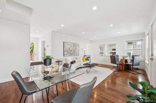 dining space featuring baseboards, wood finished floors, and recessed lighting