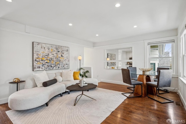living room with baseboards, wood finished floors, and recessed lighting