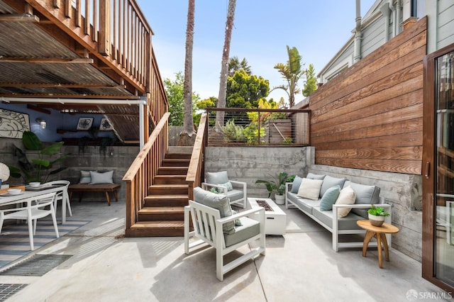 view of patio / terrace featuring stairway, outdoor lounge area, and fence