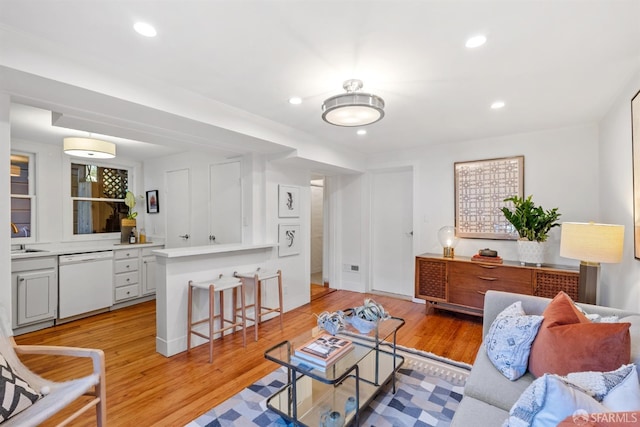 living room featuring sink and light hardwood / wood-style flooring