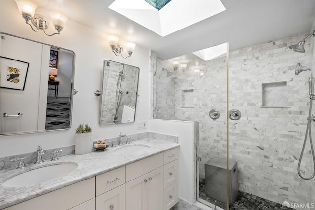 bathroom with a shower with door, vanity, and a skylight