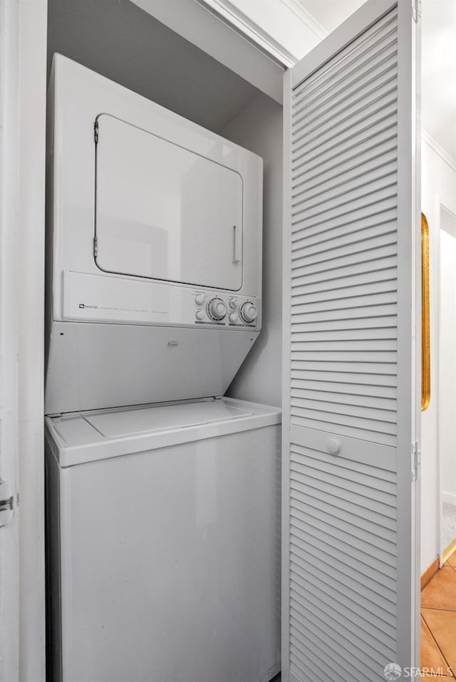 clothes washing area with stacked washer / dryer and light tile patterned floors