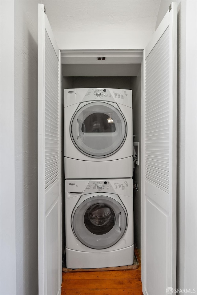 washroom featuring stacked washer / drying machine