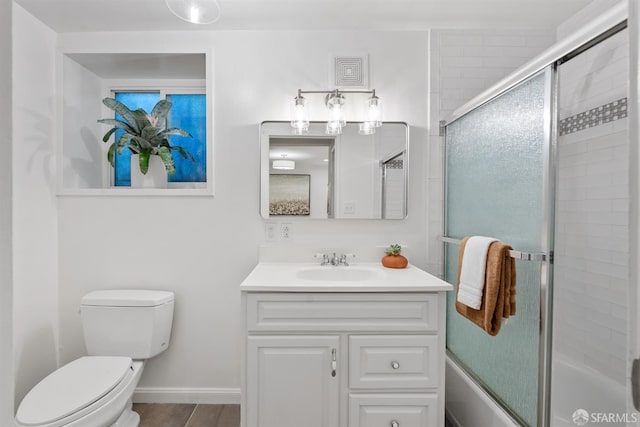 full bathroom featuring toilet, enclosed tub / shower combo, and vanity