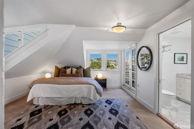 bedroom featuring connected bathroom, light carpet, and lofted ceiling