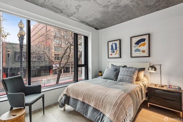 bedroom featuring multiple windows and light hardwood / wood-style flooring