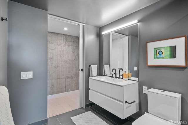 bathroom featuring tile patterned floors, vanity, toilet, and walk in shower