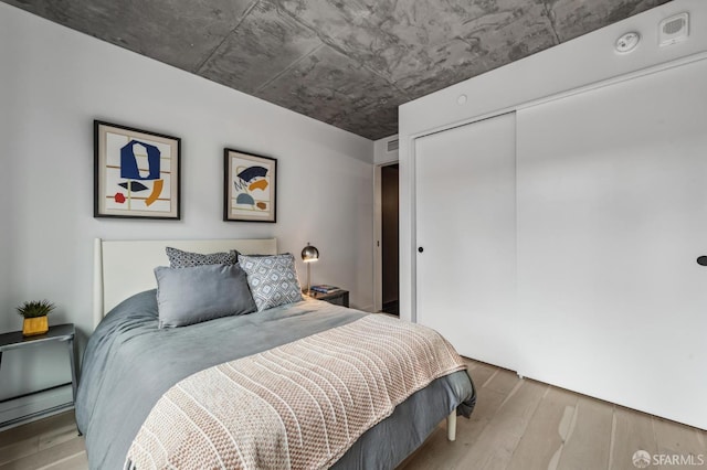 bedroom with hardwood / wood-style flooring and a closet