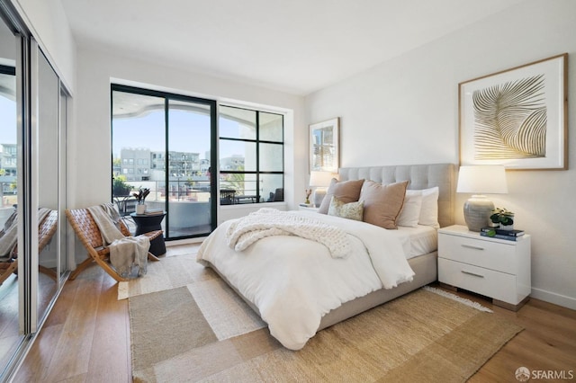 bedroom featuring access to exterior and hardwood / wood-style floors