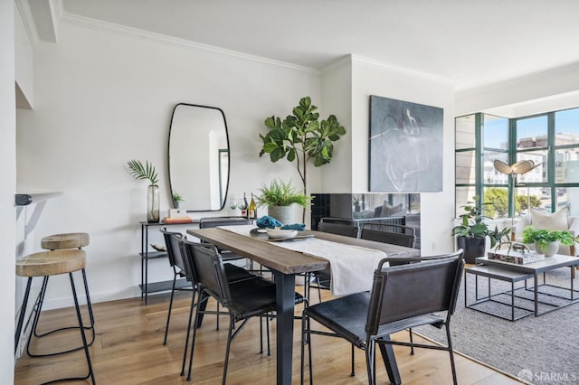 dining space featuring crown molding and hardwood / wood-style flooring