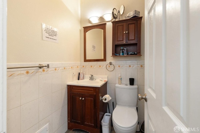 bathroom featuring tile walls, toilet, and vanity