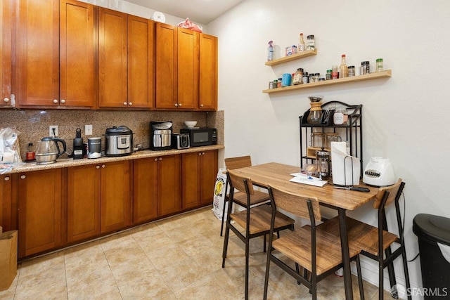 kitchen featuring tasteful backsplash and light stone counters