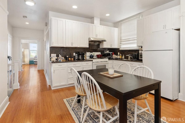 kitchen featuring tasteful backsplash, white cabinets, white appliances, and light hardwood / wood-style flooring