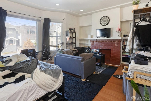 living room with a brick fireplace and hardwood / wood-style floors