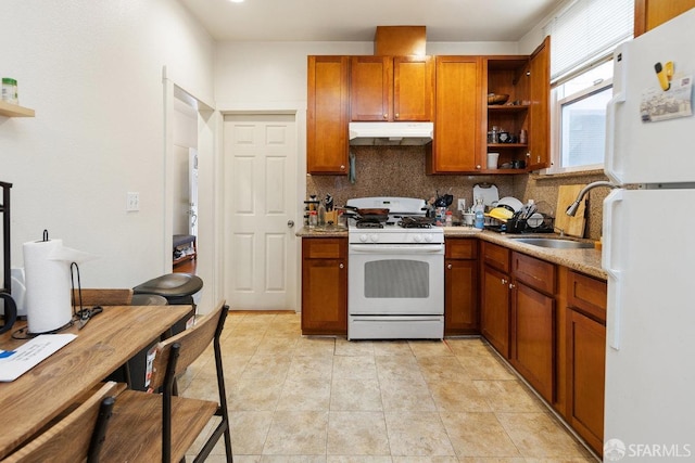 kitchen with decorative backsplash, sink, light stone counters, and white appliances