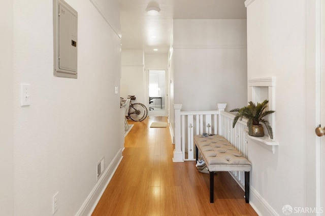 corridor with hardwood / wood-style flooring and electric panel