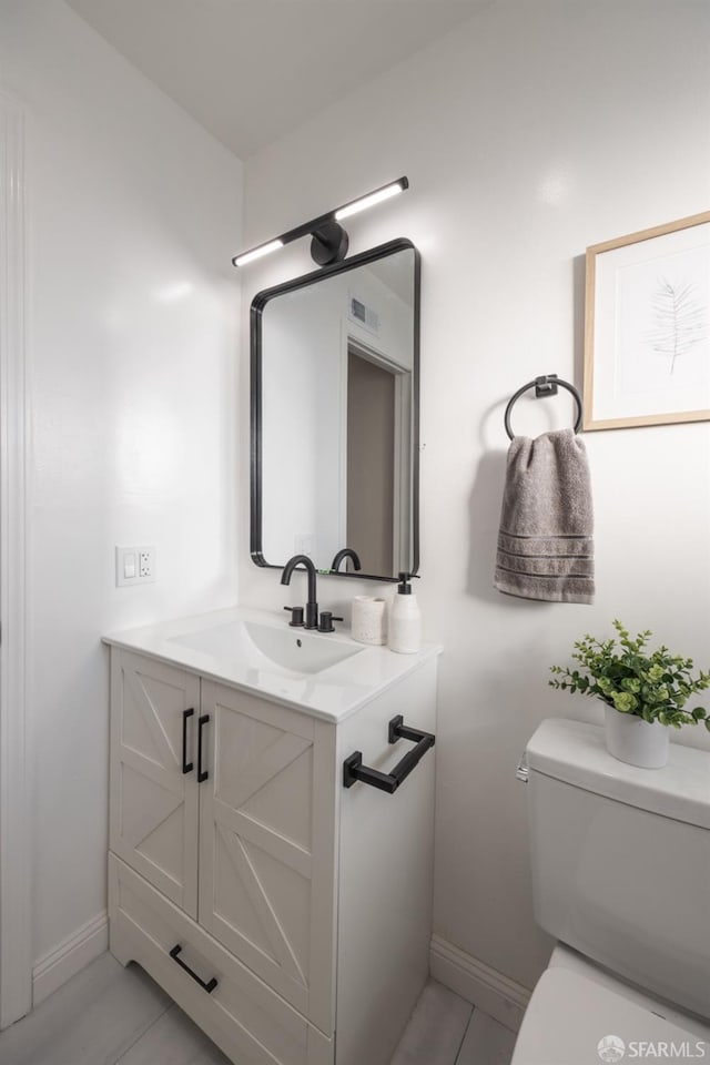 bathroom featuring vanity and toilet