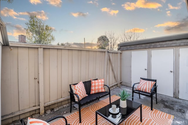 patio terrace at dusk with an outdoor hangout area and a shed