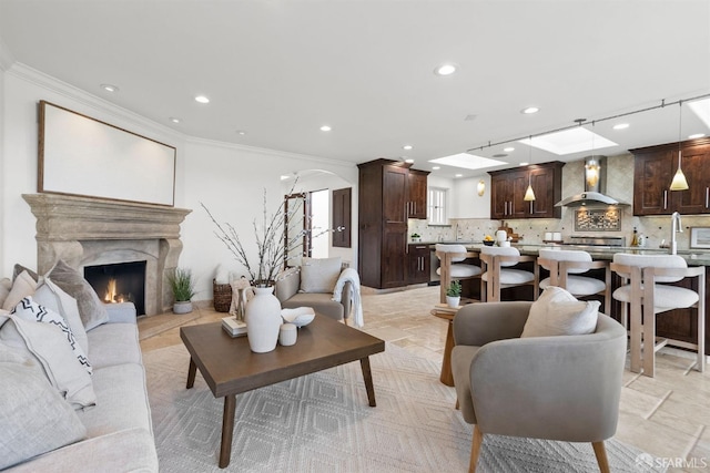 living area featuring recessed lighting, a fireplace, and crown molding