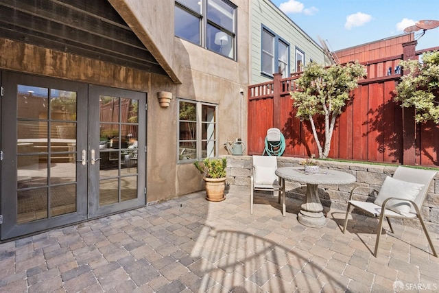 view of patio / terrace featuring french doors, outdoor dining area, and fence