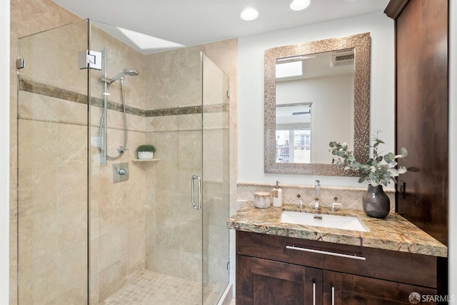 bathroom with visible vents, vanity, and a shower stall