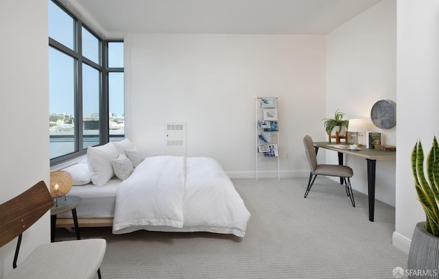 bedroom with light carpet, a wall of windows, and multiple windows