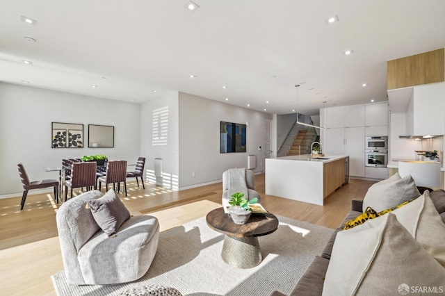 living room with sink and light hardwood / wood-style floors