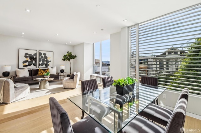 dining room with floor to ceiling windows and light hardwood / wood-style flooring