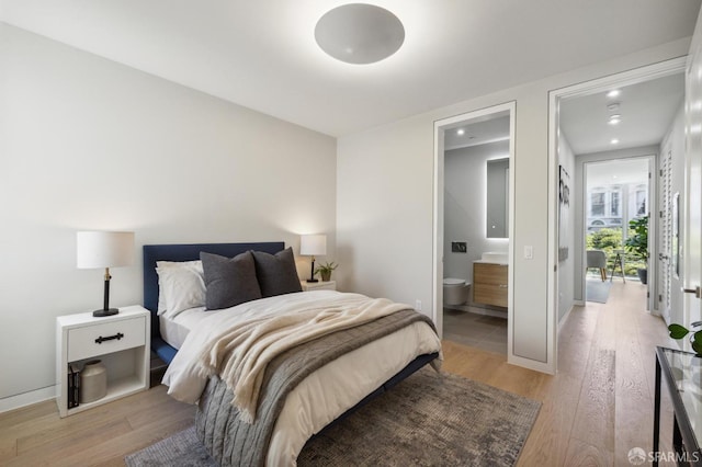 bedroom featuring ensuite bath and light hardwood / wood-style flooring