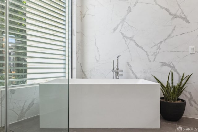 bathroom with tile patterned flooring and a washtub