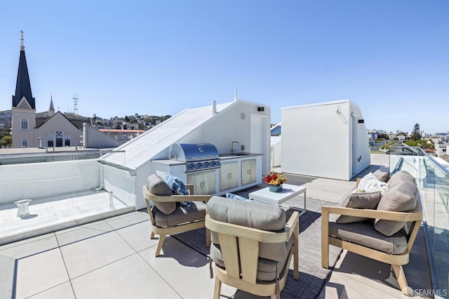 view of patio / terrace featuring area for grilling, sink, a balcony, and exterior kitchen