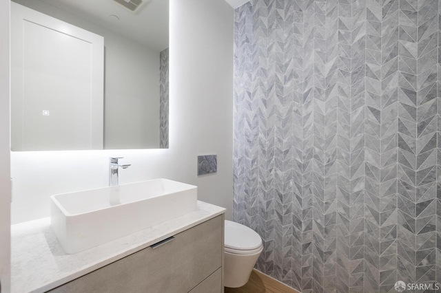 bathroom featuring vanity, hardwood / wood-style floors, and toilet