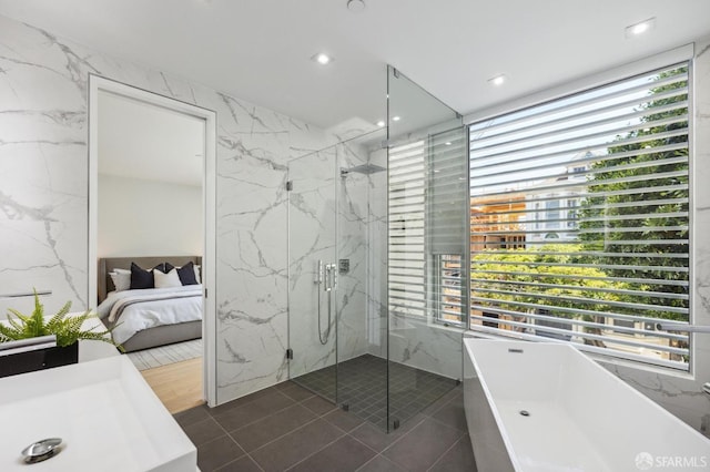 bathroom with tile patterned flooring, shower with separate bathtub, and tile walls